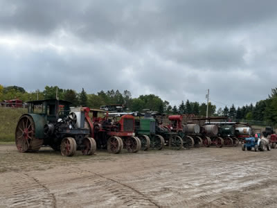 Tractors in a row parked in front of dirt